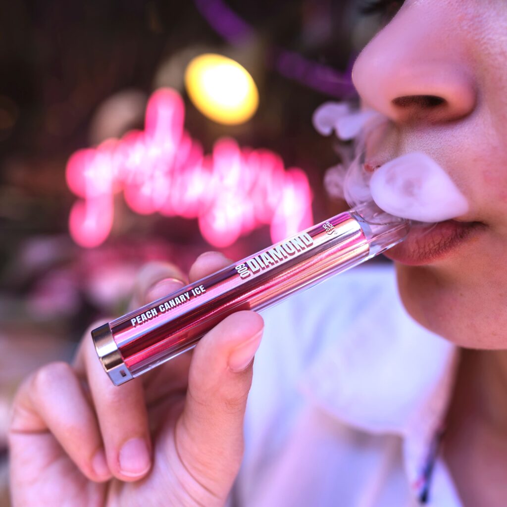 عارضة الأزياء النسائية تحمل قضبان السجائر الإلكترونية Diamond 600 Vape